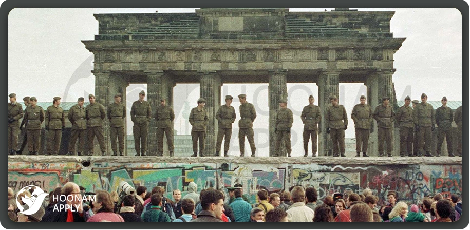 نمایی از شهروندان آلمانی که در مقابل دیوار برلین و زیر نگاه نیروهای امنیتی جمع شده‌اند تا بستگان، دوستان یا حتی فقط «سمت دیگر» را ببینند.